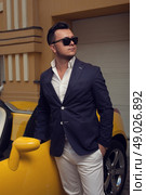 Stylish man posing with convertible sportcar. Стоковое фото, агентство Ingram Publishing / Фотобанк Лори
