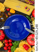 Raw pasta with ingridients and blue plate. Raw pasta with ingridients and copy space on empty blue plate. Стоковое фото, агентство Ingram Publishing / Фотобанк Лори