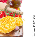 Tonarelli raw pasta. Tonarelli  raw pasta with  tomato and olive oil isolated on white background. Стоковое фото, агентство Ingram Publishing / Фотобанк Лори