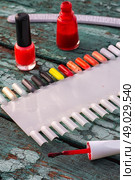 varnish for nail polish. Tubes with varnish for nail polish of different colors on an old wooden background. Стоковое фото, агентство Ingram Publishing / Фотобанк Лори