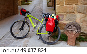 The way of Saint James stone sign in Cirauqui with bike Pamplona Spain. Стоковое фото, агентство Ingram Publishing / Фотобанк Лори