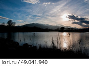 Silhouette of reeds and mountains by a lake. Стоковое фото, агентство Ingram Publishing / Фотобанк Лори