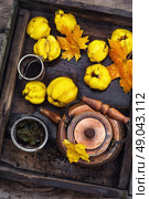 Fruit tea with quince. Copper kettle brewing and quinces in an old stylish derevna box. Стоковое фото, агентство Ingram Publishing / Фотобанк Лори