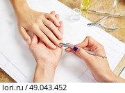 Cuticle pusher tool in nails salon woman hands treatment. Стоковое фото, агентство Ingram Publishing / Фотобанк Лори