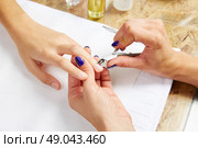 Cuticle nippers tool in nails salon woman hands treatment. Стоковое фото, агентство Ingram Publishing / Фотобанк Лори