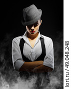 Young woman in manly style on smoke background. Стоковое фото, агентство Ingram Publishing / Фотобанк Лори