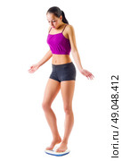 Young sporty woman on scales isolated. Стоковое фото, агентство Ingram Publishing / Фотобанк Лори