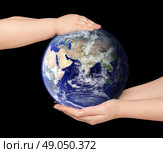 Child and woman holds earth globe on black. Стоковое фото, агентство Ingram Publishing / Фотобанк Лори