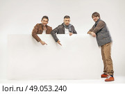 Portrait of cheerful guys holding billboard. Стоковое фото, агентство Ingram Publishing / Фотобанк Лори