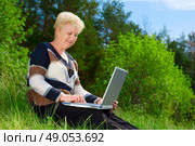 Senior woman with parasol in forest. Стоковое фото, агентство Ingram Publishing / Фотобанк Лори