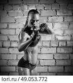 Muscular woman on grey brick wall (monochrome version) Стоковое фото, агентство Ingram Publishing / Фотобанк Лори