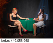 Angel and devil playing cards at room. Стоковое фото, агентство Ingram Publishing / Фотобанк Лори