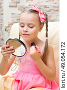 Little girl doing makeup at light room. Стоковое фото, агентство Ingram Publishing / Фотобанк Лори
