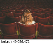 Rear view shot of a young woman sitting alone in an auditorium. Стоковое фото, агентство Ingram Publishing / Фотобанк Лори