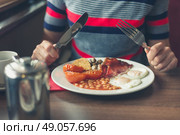 A young woman is having a traditional english breakfast in a diner. Стоковое фото, агентство Ingram Publishing / Фотобанк Лори