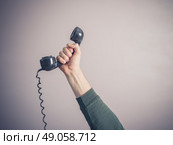 The hand of a young man is holding a vintage rotary telephone. Стоковое фото, агентство Ingram Publishing / Фотобанк Лори