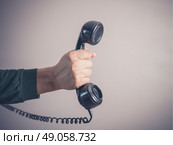 The hand of a young man is holding a vintage rotary telephone. Стоковое фото, агентство Ingram Publishing / Фотобанк Лори