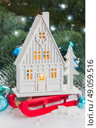 White christmas house. White christmas house on red sledge with blue decorations in snow. Стоковое фото, агентство Ingram Publishing / Фотобанк Лори