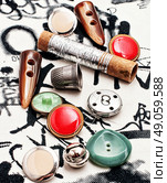 spool of thread and buttons. Silver bobbin of thread and a set of buttons. Стоковое фото, агентство Ingram Publishing / Фотобанк Лори