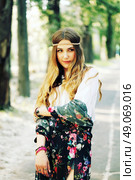 Fashion portrait of beautiful hippie young woman wearing boho chic clothes and summer hat outdoors. Soft warm vintage color tone. Artsy bohemian style. Стоковое фото, агентство Ingram Publishing / Фотобанк Лори