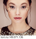 Portrait of beautiful young woman in a shiny golden dress. Brunette girl. Perfect make-up. Freckles. Стоковое фото, агентство Ingram Publishing / Фотобанк Лори