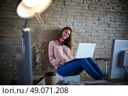 Businesswoman young casual sitting at office working with laptop computer feet on table relaxed. Стоковое фото, агентство Ingram Publishing / Фотобанк Лори