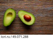 avocado cut on aged wood table board cutted half. Стоковое фото, агентство Ingram Publishing / Фотобанк Лори