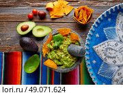 Guacamole with nachos avocado in Mexican molcajete and Sombrero hat. Стоковое фото, агентство Ingram Publishing / Фотобанк Лори