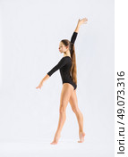 Young girl engaged art gymnastic on grey. Стоковое фото, агентство Ingram Publishing / Фотобанк Лори