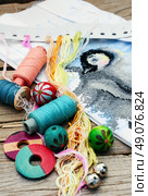 Set of threads for embroidery on background of handmade paintings. Parts and accessories embroidery. Стоковое фото, агентство Ingram Publishing / Фотобанк Лори