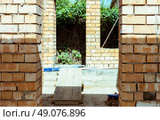 house under constraction with modern brick walls and holes for doors and windows. Стоковое фото, фотограф Feruza Tashmetova / Фотобанк Лори