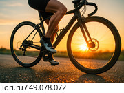 Closeup legs of cyclist accelerating on asphalt road at sunset symbolizing quick progress business startup speed persistence drive success. Стоковое AI-изображение, AI-художник Павел Муравьев / Фотобанк Лори