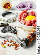 Dish of raw minced beef meat and parts of meat grinder. Raw minced beef. Стоковое фото, агентство Ingram Publishing / Фотобанк Лори