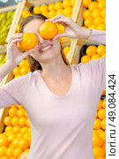 Playful woman covering her eyes with oranges. Стоковое фото, агентство Ingram Publishing / Фотобанк Лори