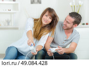 Chilling out at home with a games console. Стоковое фото, агентство Ingram Publishing / Фотобанк Лори