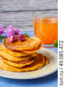  fritter pancakes with light dishes and glass of juice. pancakes with pumpkin. Стоковое фото, агентство Ingram Publishing / Фотобанк Лори