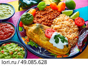 Chili relleno chili pepper poblano filled with cheese in dish with with rice and frijoles beans. Стоковое фото, агентство Ingram Publishing / Фотобанк Лори