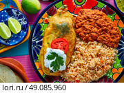 Chili relleno chili pepper poblano filled with cheese in dish with with rice and frijoles beans. Стоковое фото, агентство Ingram Publishing / Фотобанк Лори