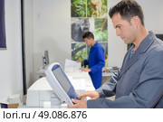 Man using control pad on printer. Стоковое фото, агентство Ingram Publishing / Фотобанк Лори