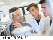 Teacher with students next to model. Стоковое фото, агентство Ingram Publishing / Фотобанк Лори