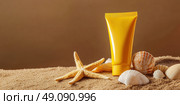Yellow Sunscreen cream tube, starfishes and seashells on a sand top view. Cosmetic mockup. Sunblock lotion on sandy beach background. Summer vacation care concept, sun screen product, spf uv protect. Стоковое AI-изображение, AI-художник Марина Демидюк / Фотобанк Лори