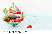Bowls with fresh Strawberries and sugar strainer on light blue background, side view, banner. Стоковое фото, агентство Ingram Publishing / Фотобанк Лори