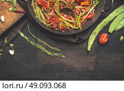 Sliced  green French beans with tomatoes sauce on dark rustic background, top view, border. Healthy and vegetarian food concept. Стоковое фото, агентство Ingram Publishing / Фотобанк Лори