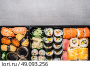 Various sushi menu in black transport box or bento box on gray  stone background, top view, border.  Japanese and Asian food. Стоковое фото, агентство Ingram Publishing / Фотобанк Лори