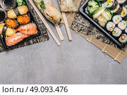 Sushi menu with nigiri, maki and inside rolls, summer rolls in rice paper wrappers  on gray on gray  stone background, top view, border.  Japanese and Asian food. Стоковое фото, агентство Ingram Publishing / Фотобанк Лори