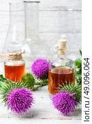 Flower and burdock extract. Buds medicinal wild plants burdock and burdocks medicinal tincture from it. Стоковое фото, агентство Ingram Publishing / Фотобанк Лори