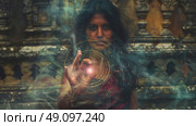 A woman with dark hair stands in front of an ancient temple, her hand outstretched, casting a spell with swirling energy. Стоковое AI-изображение, AI-художник Данила Большаков / Фотобанк Лори