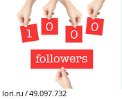 1000 followers written on cards held by hands. Стоковое фото, агентство Ingram Publishing / Фотобанк Лори