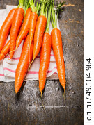 New carrots bunch on dark rustic wooden background, close up. Стоковое фото, агентство Ingram Publishing / Фотобанк Лори