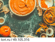 Traditional pumpkin pie preparation with filling, dough and ingredients on dark rustic background, top view, retro styled, frame. Стоковое фото, агентство Ingram Publishing / Фотобанк Лори